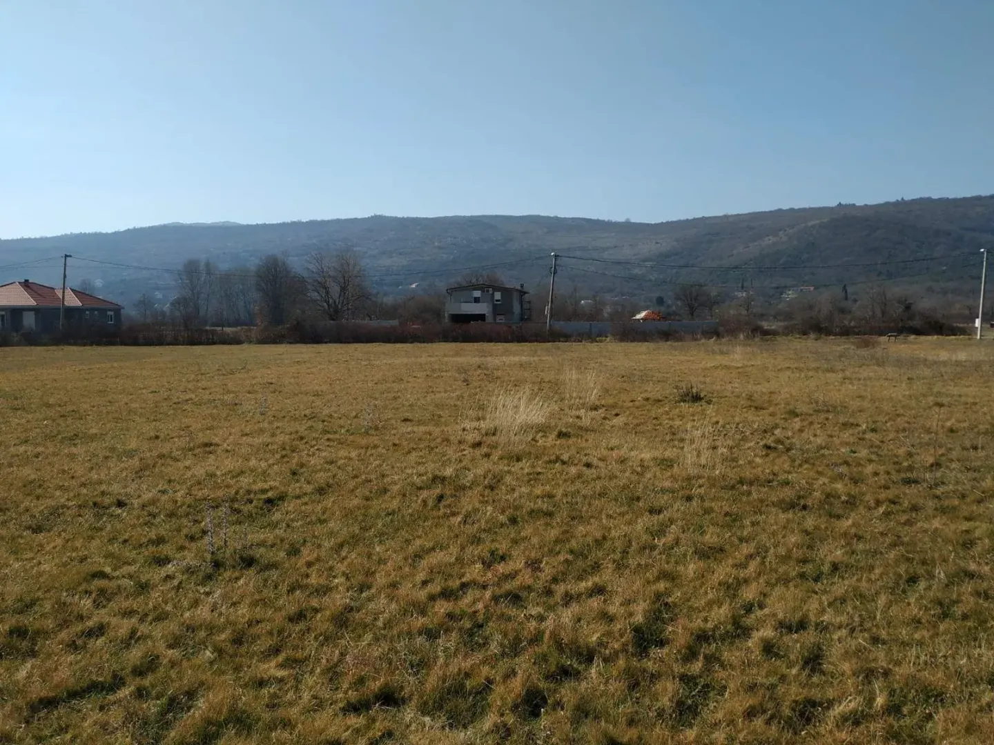 Pogled na prostrano zemljište sa brdima u pozadini.