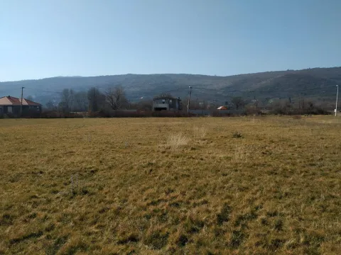 Pogled na prostrano zemljište sa brdima u pozadini. - image 7