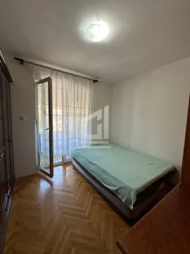Namještena spavaća soba sa krevetom i izlazom na terasu. - image 3