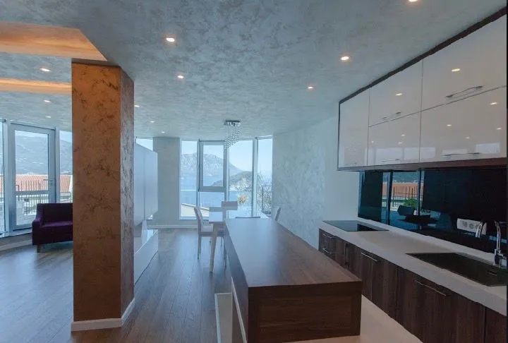 Modern kitchen with a bar counter and dining area in an open space with a sea view.