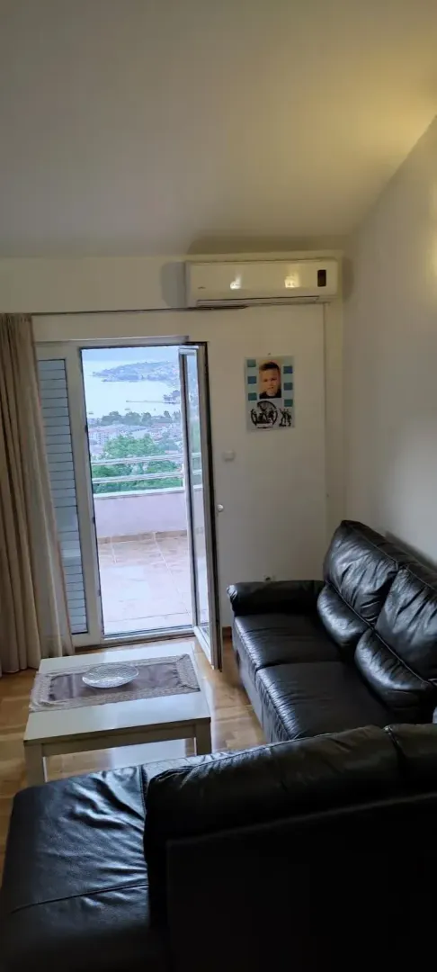 Living room with black leather sofas and access to the terrace.