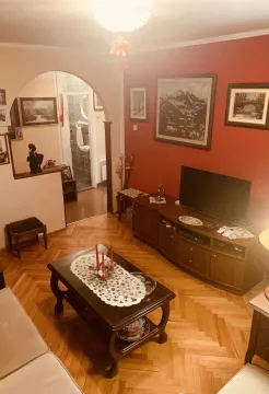 Living room with wooden furniture, a television, and parquet flooring. - image 4