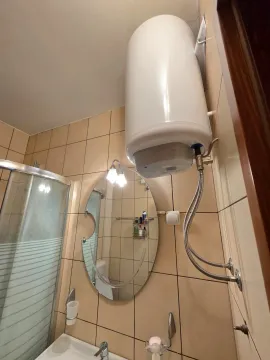Pogled na kupatilo sa bojlerom, ogledalom i tuš kabinom. - image 11