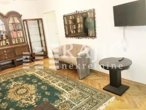 Dnevna soba sa garniturom, komadnim nameštajem i televizorom na zidu. - image 2