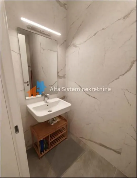 Small tiled bathroom with a washbasin and a mirror.