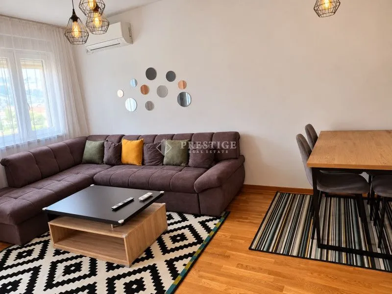 Dnevna soba sa garniturom, trpezarijskim stolom i modernim detaljima.