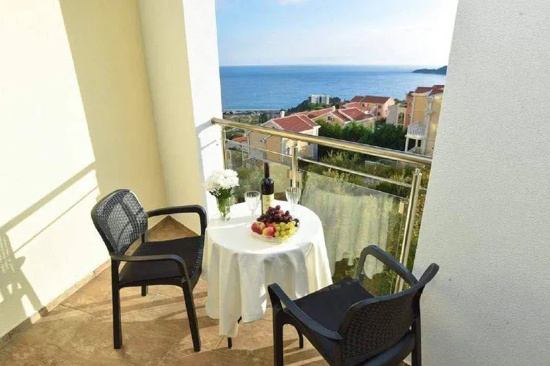 Namješten balkon sa stolom, stolicama i pogledom na more.