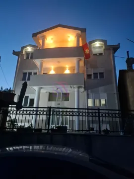 View of a multi-story house with an illuminated terrace at dusk. - image 24