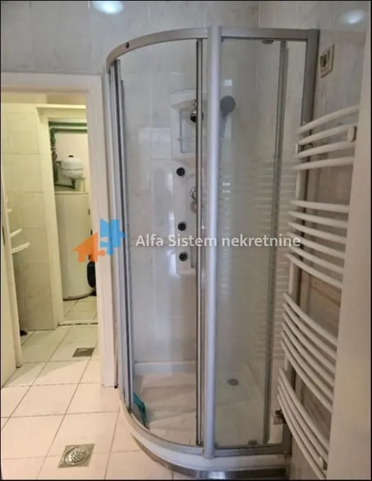 Bathroom with a shower cabin and a towel radiator.