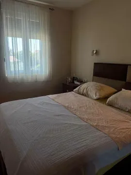 Spavaća soba sa bračnim krevetom i prozorom sa zavjesama. - image 3