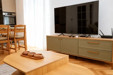 Dnevna soba sa televizorom, komodom i drvenim stočićem. - image 4