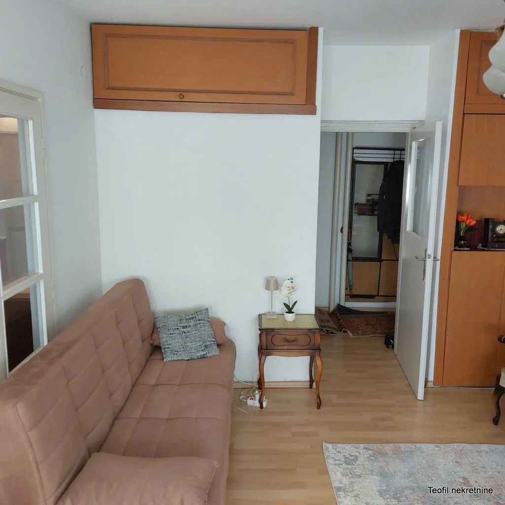 Dnevni boravak sa kaučem, noćnim stočićem i ugradnim ormanom.