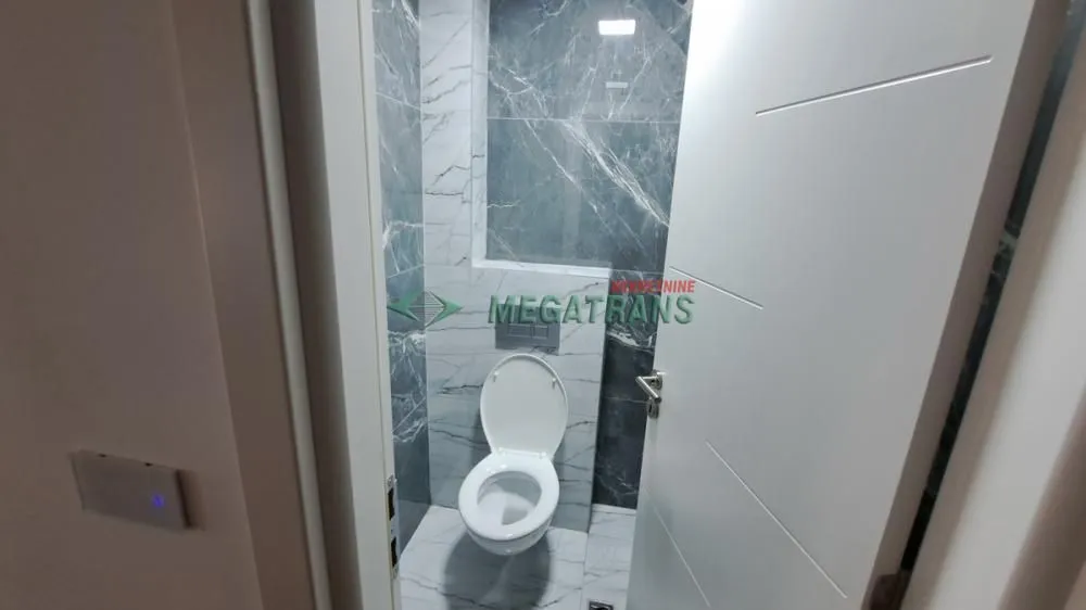 Manje kupatilo obloženo keramičkim pločicama sa ugradnom wc šoljom.