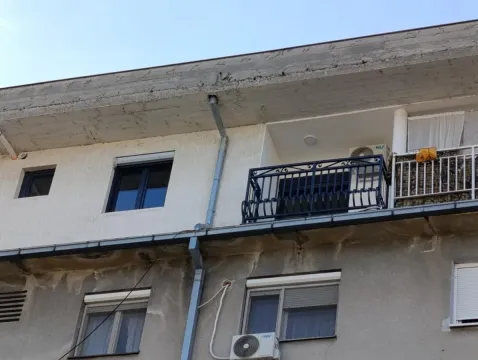 Pogled na spoljni deo stambene zgrade sa prozorima i balkonom. - image 4
