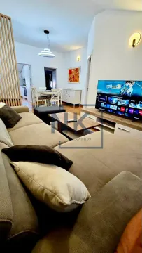 Prostrani dnevni boravak sa garniturom i televizorom, povezan sa trpezarijom. - image 2