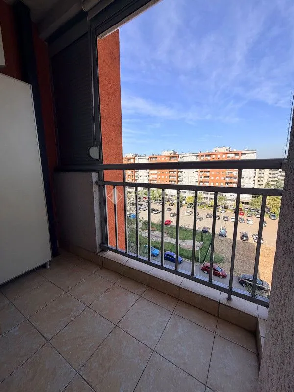 Small tiled balcony with a railing and a view of the neighborhood.