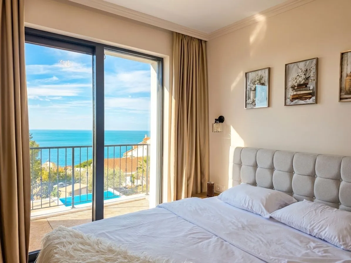 Bedroom with a double bed and a sea view through balcony doors.