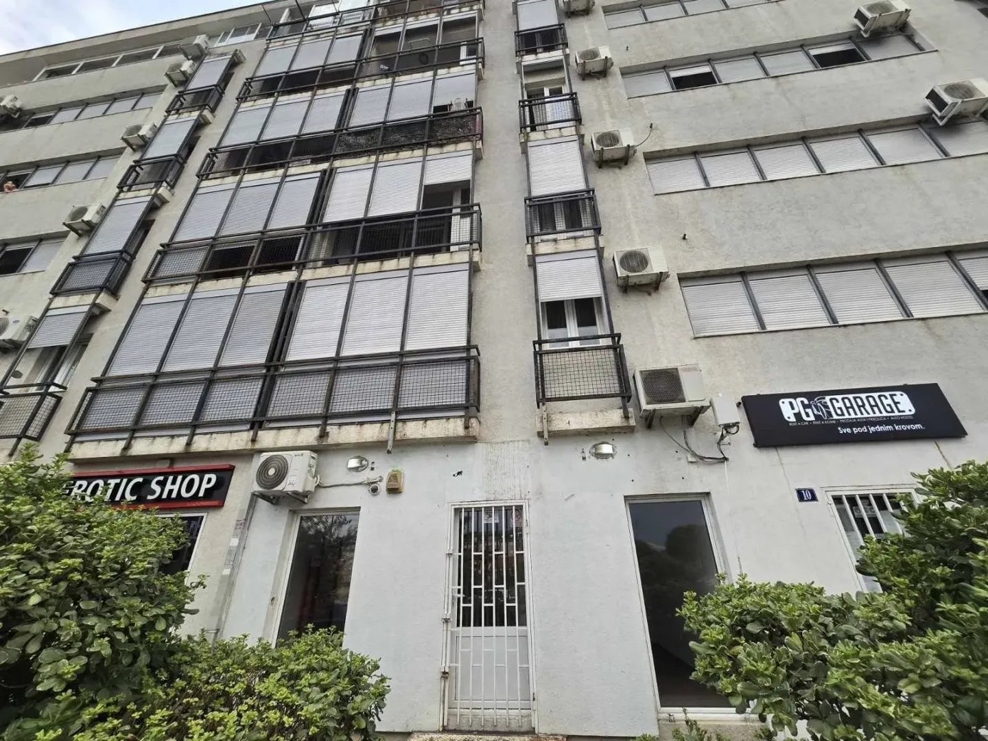Exterior of a multi-story building with commercial spaces on the ground floor.
