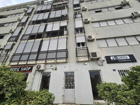 Exterior of a multi-story building with commercial spaces on the ground floor. - image 4