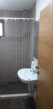 Small bathroom with a white sink and patterned tiles. - image 18