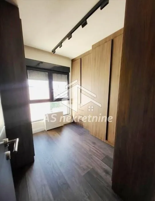 Small bedroom with a built-in wardrobe and wooden flooring.