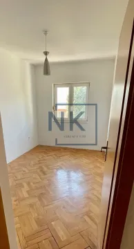 An empty room with parquet flooring and a single window. - image 9