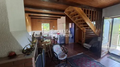 Living room with dining area and wooden staircase. - image 7