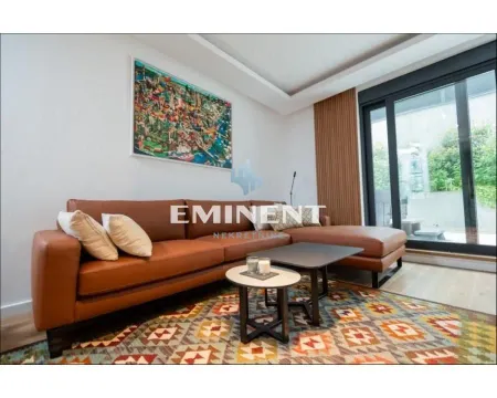 Living room with a leather sofa, coffee tables, and a large window. - image 2