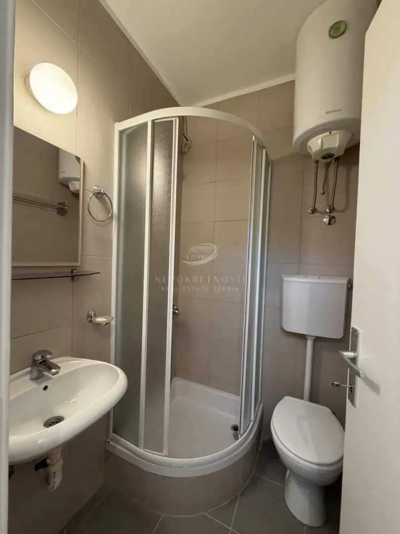 Manje kupatilo sa tuš kabinom, umivaonikom i wc šoljom.