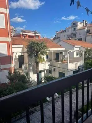 Pogled sa terase na okolne zgrade i mediteransko rastinje.