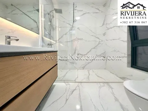 Modernly equipped bathroom with a walk-in shower and marble tiles. - image 13