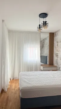 Svijetla spavaća soba sa bračnim krevetom, bijelim zavjesama i drvenim podom. - image 6