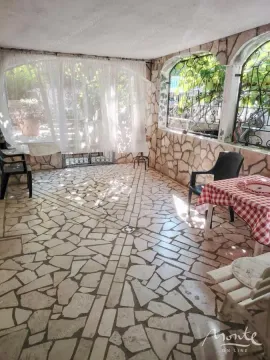 Natkrivena terasa popločana kamenom sa stolovima i stolicama. - image 19