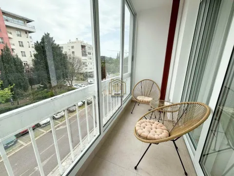 Zastakljeni balkon sa garniturom za sjedenje i pogledom na grad. - image 7