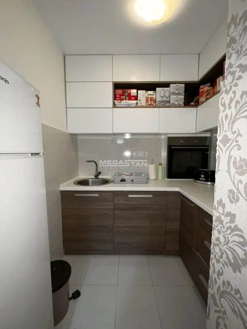 Smaller kitchen with white and wooden cabinets.