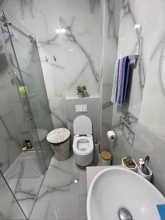 Manje kupatilo sa tuš kabinom, WC šoljom i umivaonikom.