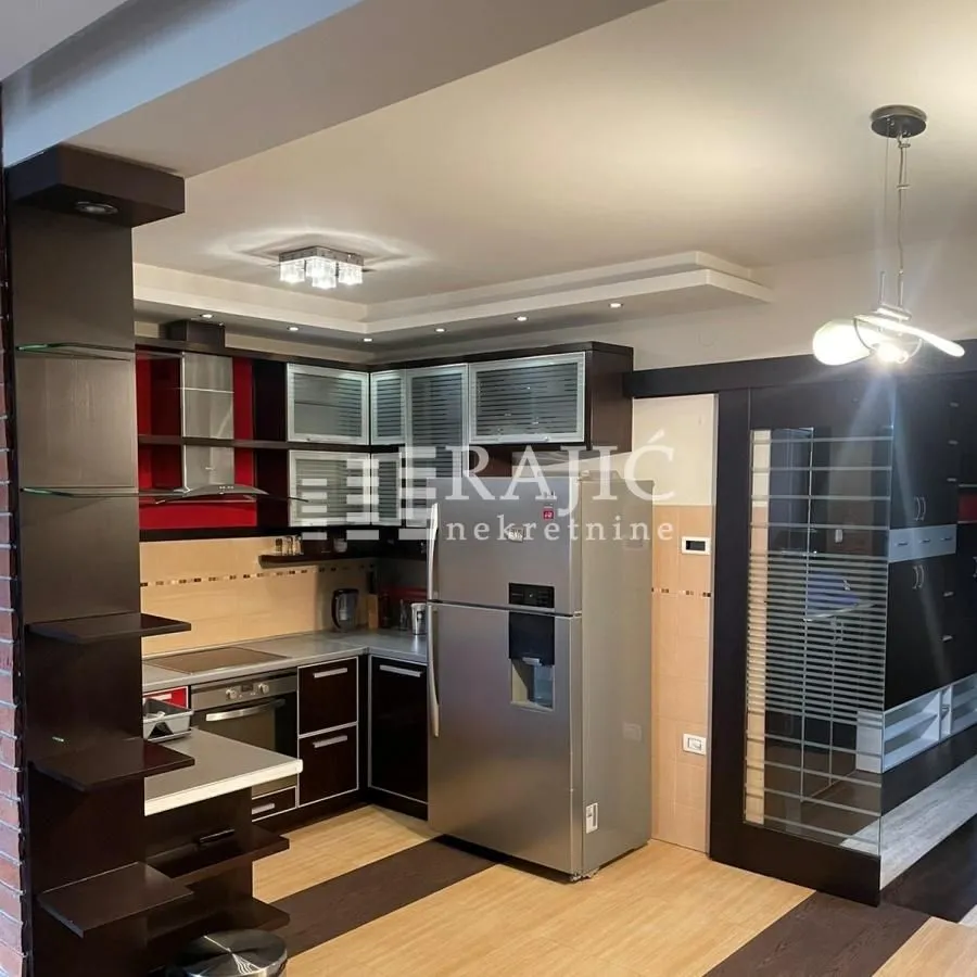 Modern kitchen with dark cabinets and built-in appliances.