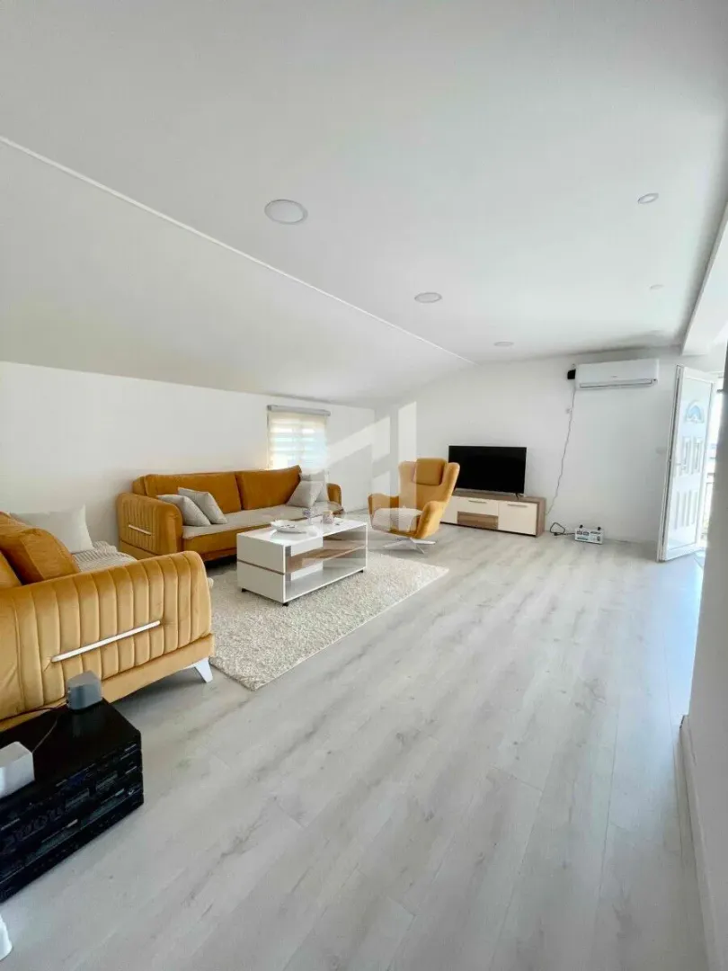 Spacious living room with a sofa set, coffee table, and television.