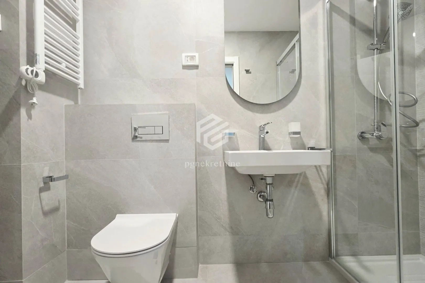 Moderne kupatilo sa tuš kabinom, umivaonikom i ugradnom wc šoljom.