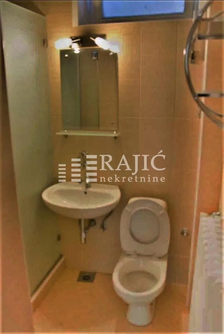 Manje kupatilo sa umivaonikom, wc šoljom i tuš kabinom.