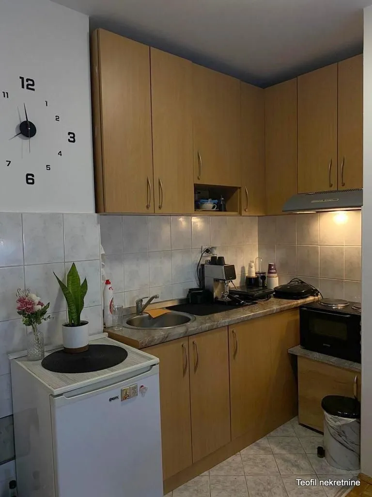 Small kitchen with wooden cabinetry, sink, and countertops.