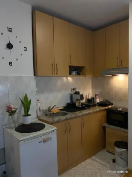 Small kitchen with wooden cabinetry, sink, and countertops. - image 3