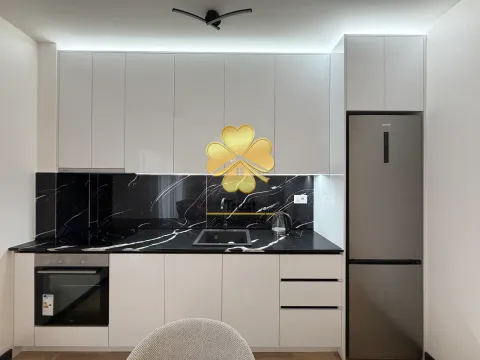 Moderna kuhinja sa bijelim elementima, crnom mermernom radnom pločom i ugrađenim frižiderom. - image 5