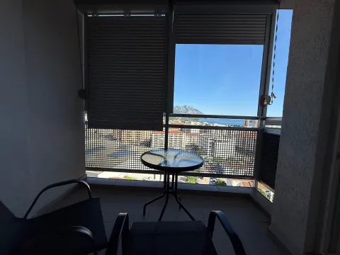 Enclosed balcony with seating furniture and views of the city and sea. - image 13