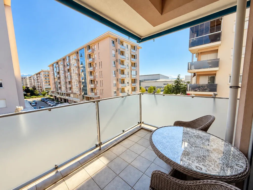 Furnished balcony with seating set and city view.