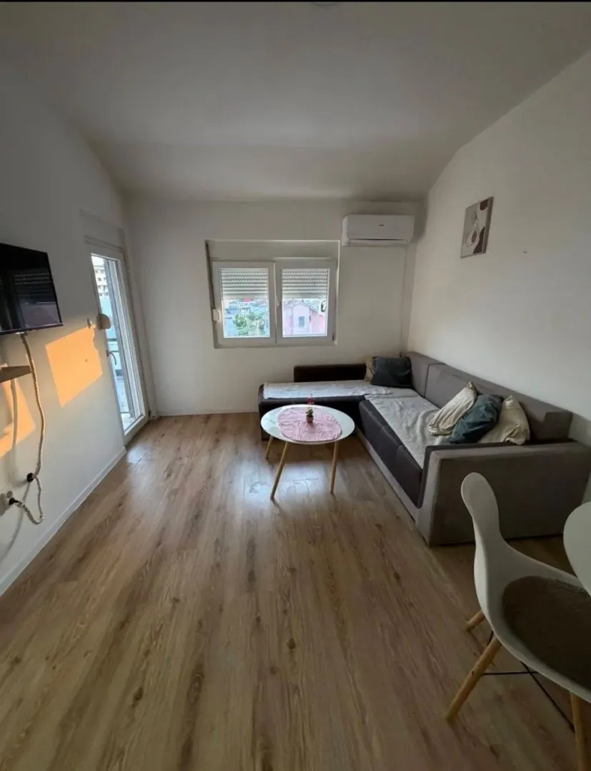 Living room with a sofa, coffee table and parquet flooring.