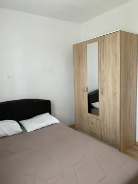 Bedroom with a double bed and a wooden wardrobe with a mirror. - image 6