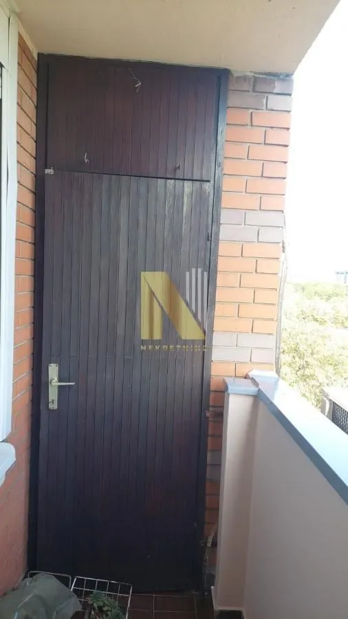 Terrace with a wooden door and a brick wall.