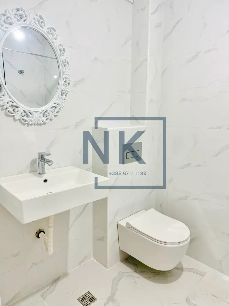 Modern bright tiles in the bathroom with a washbasin, mirror, and toilet.