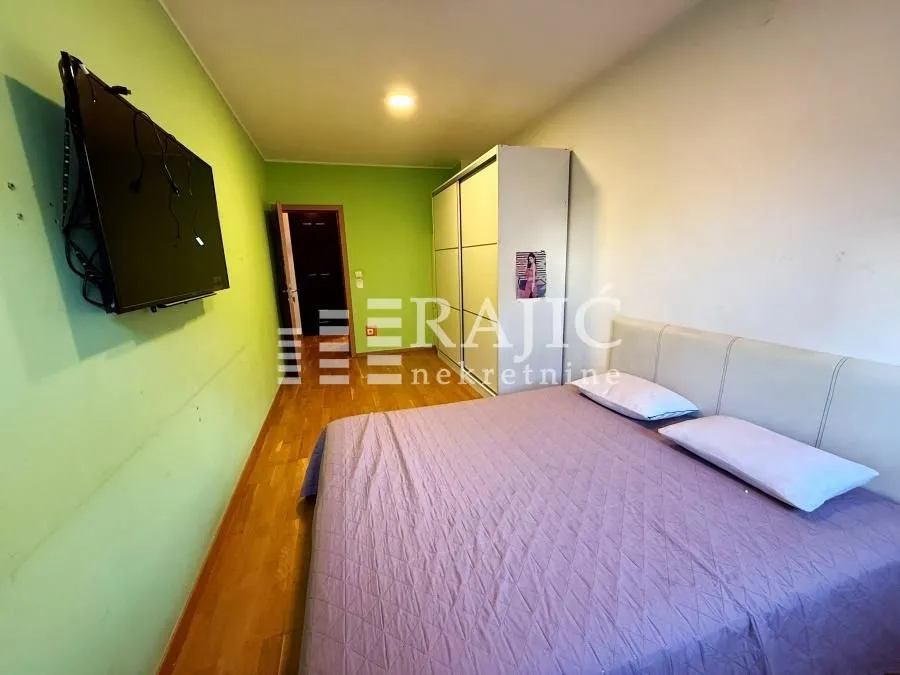 Bedroom with a double bed, wardrobe, and wall-mounted TV.